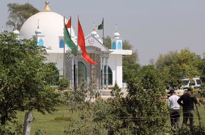 Members of the police forensic unit (R) survey the scene outside a Sufi shrine, after an attack at the shrine, on the outskirts of Sargodha, Pakistan April 2, 2017. REUTERS/Stringer