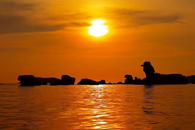 The stunning sunset scene at Hon Dam Ngang islet. The rocks rise from the water as lions heading towards the sea.