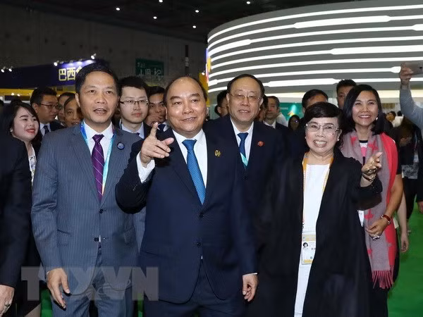 Prime Minister Nguyen Xuan Phuc (second from left) visits Vietnam's national stall at China International Import Expo 2018 (Source: VNA)