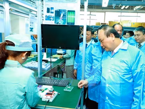 Prime Minister Nguyen Xuan Phuc visits a production facility of Vietnam Post and Telecommunication Industry Technology JSC at Hoa Lac Hi-Tech Park