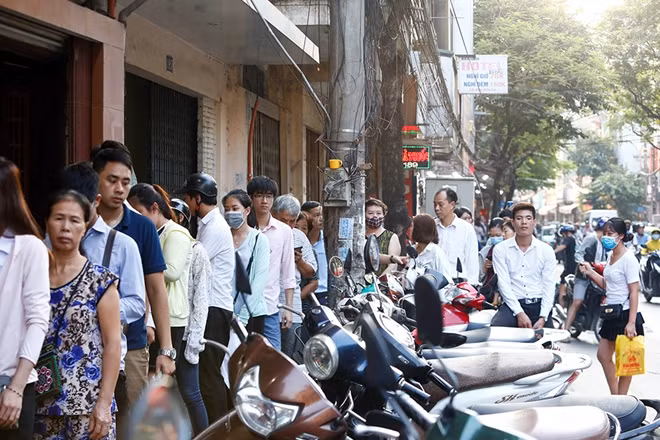 There are hundreds of customers in front of the shop-window but they are all in an orderly line.