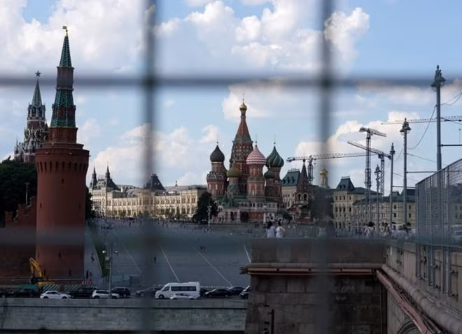 A view through a construction fence shows the Kremlin towers and St. Basil's Cathedral on a hot summer day in central Moscow, Russia, July 1, 2016. REUTERS/Maxim Zmeyev