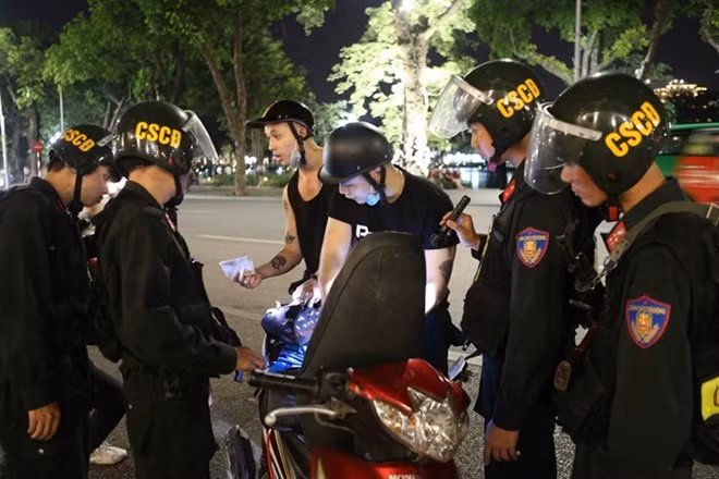 Police stop a motorbike driver near Hoan Kiem Lake in the capital city. (Photo: VNA)