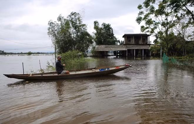 A local resident in Quang Dien district of Thua Thien-Hue travel by boat during a flood (Photo: VNA)