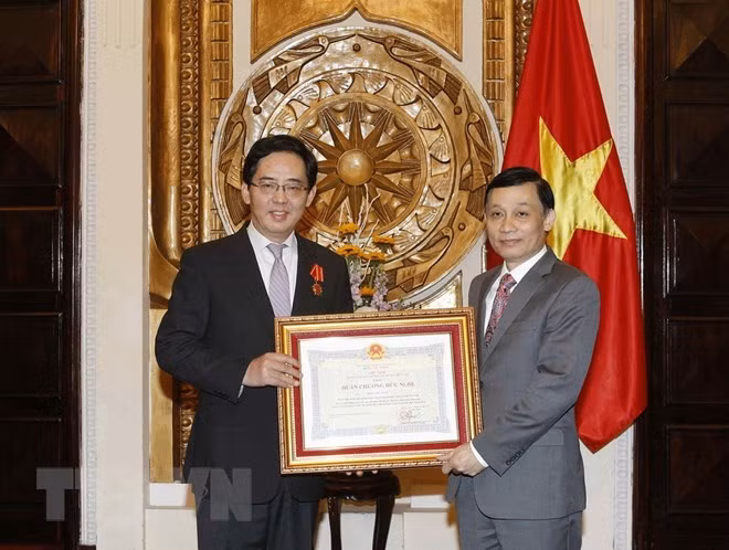 Deputy Foreign Minister Le Hoai Trung (R) presents Friendship Order to Chinese Ambassador Hong Xiaoyong
