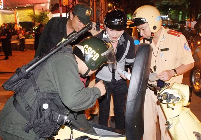 HCM City police search a motorbike after midnight on Tran Huan Nghiep Street, District 1 during a campaign to curb crimes at spots notorious for crime in the city. — VNA/VNS Photo