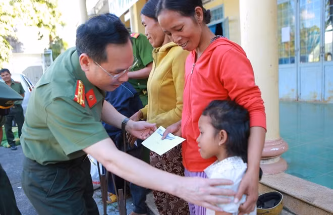 Senior Colonel Tran Thanh Phong, ice Editor-in-Chief of the CAND Newspaper presents gifts to local people
