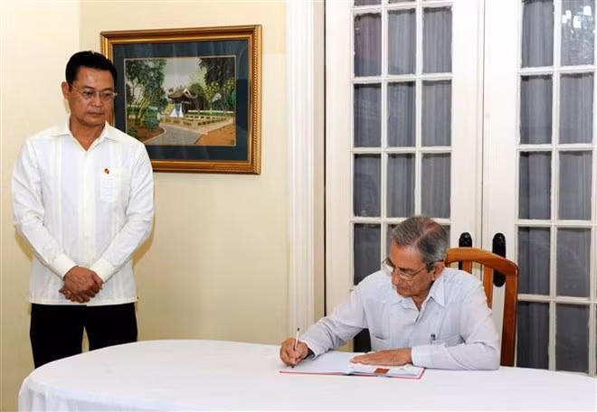 Cuban Secretary of the Party Central Committee José Ramón Balaguer writes in the funeral book at the Vietnamese Embassy in Cuba. (Photo: VNA)