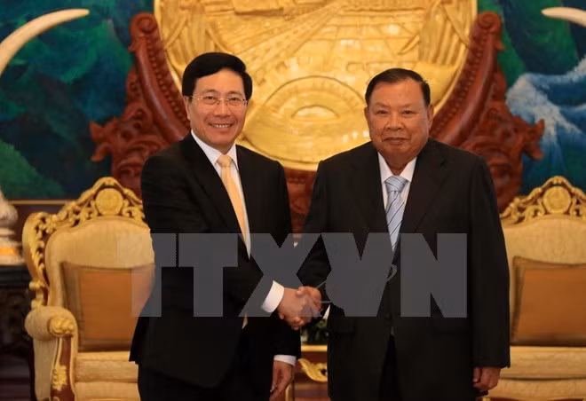 Deputy Prime Minister and Foreign Minister Pham Binh Minh (L) meets with Party General Secretary and President of Laos Bounnhang Vorachith (Photo: VNA) Deputy Prime Minister and Foreign Minister Pham Binh Minh (L) meets with Party General Secretary and President of Laos Bounnhang Vorachith (Photo: VNA)