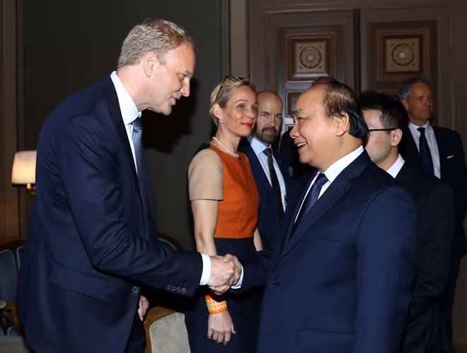 Prime Minister Nguyen Xuan Phuc (R) shakes hands with a Swedish business executive at a meeting in Stockholm on May 27.