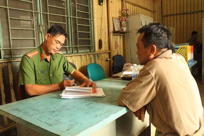 A police officer helps local people solve administrative documents.