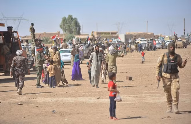 REFILE-CORRECTING TYPO Civilians are seen with Shi'ite Popular Mobilization Forces (PMF) on the outskirts of Hawija, Iraq, October 1, 2017. REUTERS