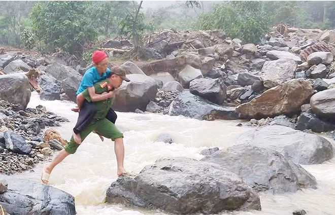 A police officer of Thanh Hoa helps an elderly to cross a stream. A police officer of Thanh Hoa helps an elderly to cross a stream.