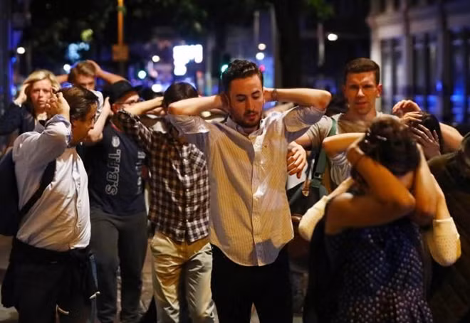 People leave the area with their hands up after an incident near London Bridge in London, Britain June 4, 2017. REUTERS/Neil Hall
