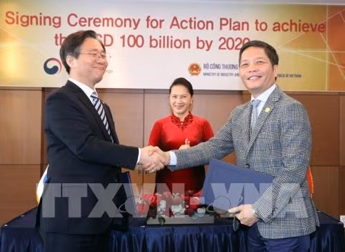 Vietnamese Minister of Industry and Trade Tran Tuan Anh (R) and Korean Minister of Trade, Industry, and Energy Sung Yunmo signed a MoU in Seoul on December 6 on an action plan for attaining 100 billion USD in bilateral trade by 2020 (Photo: VNA)