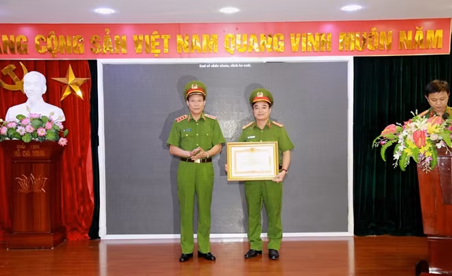 Deputy Minister Le Quy Vuong presents a Certificate of Merit of the Prime Minister to an outstanding officer.