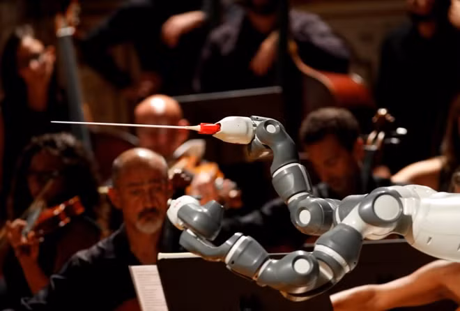 Humanoid robot YuMi conducts the Lucca Philharmonic Orchestra performing a concert alongside Italian tenor Andrea Bocelli (unseen) at the Verdi Theatre in Pisa, Italy September 12, 2017. REUTERS.