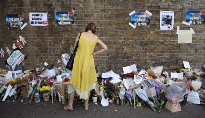A woman looks at messages at the base of a wall near the scene of an attack next to Finsbury Park Mosque, in north London, Britain June 20, 2017. REUTERS/Marko Djurica