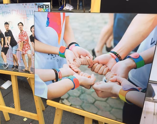 A photo on display at an exhibition as part of "Steps for LGBT" event held by iSEE in Hanoi on May 6. The photo shows people wearing wristbands of rainbow, a symbol of LGBT community. (Photo: VNA)