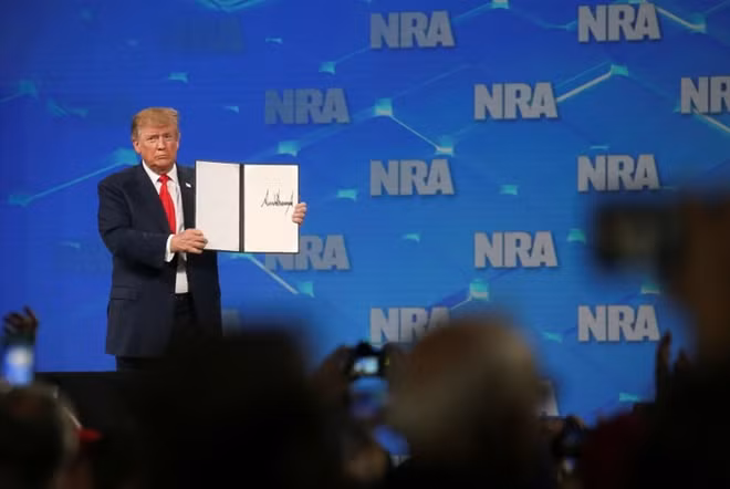 U.S. President Donald Trump holds up an executive order with his signature as he announces that the United States will drop out of an international arms treaty during a speech at the National Rifle Association-Institute for Legislative Action's (NRA-ILA) 148th annual meeting in Indianapolis, Indiana, U.S., April 26, 2019. REUTERS