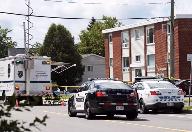 Fredericton Police and Royal Canadian Mounted Police investigate an apartment complex in Fredericton, New Brunswick, that was the scene of a shooting. (Dan Culberson/Reuters)