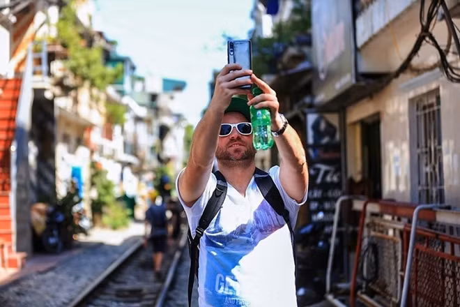 A foreigner is taking a selfie at the train street