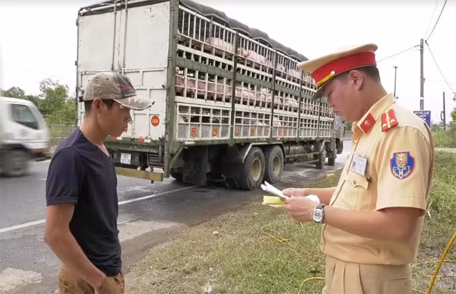 A traffic police officer checks documents of a driver at the checkpoint on the National Highway. A traffic police officer checks documents of a driver at the checkpoint on the National Highway.