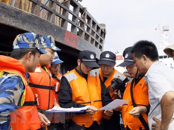 Vietnamese and Chinese coast guards check operation licenes of fishermen. (Photo: VNA)