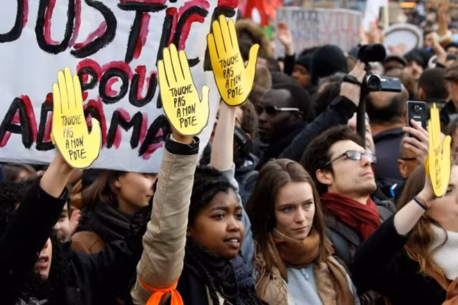 Demonstrators hold SOS anti-racism symbols which read ' Dont touch my friend ' to protest against police brutality after a young black man, 22-year-old youth worker named Theo, was severely injured during his arrest earlier this month in Bobigny, as people gather at a demonstration in Paris, France, February 18, 2017. REUTERS/Charles Platiau