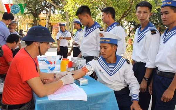An official from the National Institute of Hematology and Blood Transfusion (in red) draws blood from a soldier on the Truong Sa archipelago for blood examination. — Photo vov.vn An official from the National Institute of Hematology and Blood Transfusion (in red) draws blood from a soldier on the Truong Sa archipelago for blood examination. — Photo vov.vn