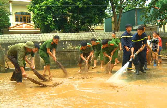 Police officers and soldiers clean the flood-hit houses, schools...