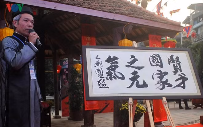 Tran Quoc Chi, deputy head of the UNESCO Calligraphy Club, writes a sign in calligraphy to open the festival
