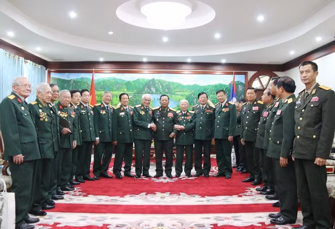Participants in the meeting between Lao Defence Minister Gen. Chansamone Chanyalath and former volunteer soldiers and advisors of Vietnam pose for a photo (Photo: VNA)