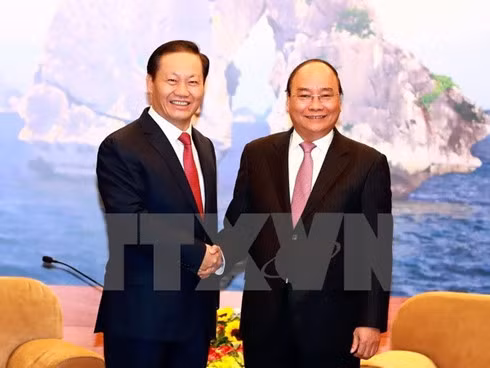 Prime Minister Nguyen Xuan Phuc (R) shakes hands with Peng Qing Hua, Secretary of the Party Committee of China’s Guangxi Zhuang Autonomous Region