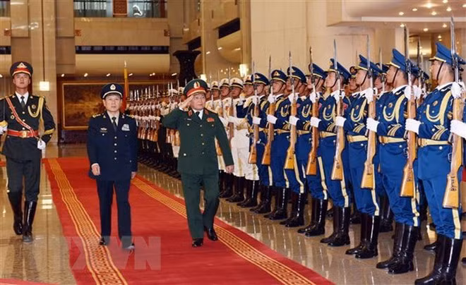 Defence Minister General Ngo Xuan Lich (right) inspects the guard of honour of China. (Photo: VNA)