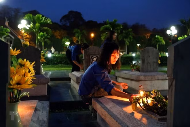 Youths light candles at all tombs (Source: VNA)