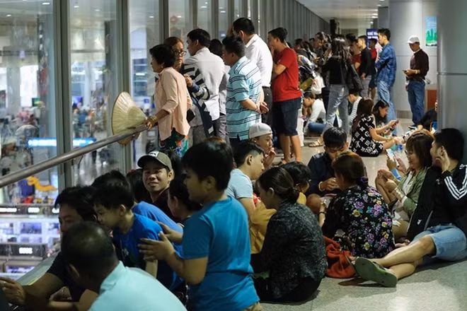 Some people go upstairs so they can spot their relatives easily while the crowds jostle their way to the terminal. Photo: Vnexpress