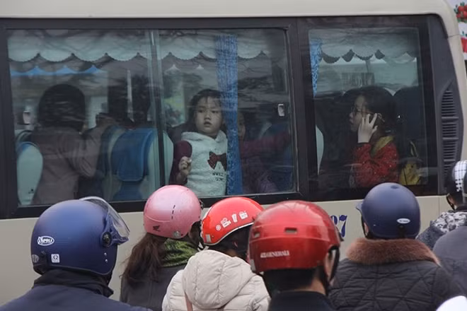 Primary school students look tired on a school bus at Giap Nhat Street. Photo: Vietnamnet