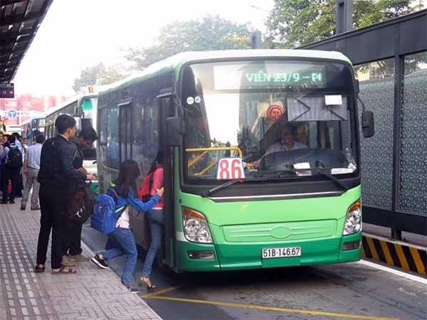 Passengers get on a bus on Ham Nghi Street, HCM City. — VNA/VNS Photo