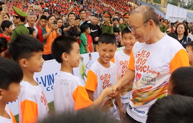 Head coach of the national men’s football team Park Hang-seo (R) shakes hands with the students (Photo: VNA) Head coach of the national men’s football team Park Hang-seo (R) shakes hands with the students (Photo: VNA)