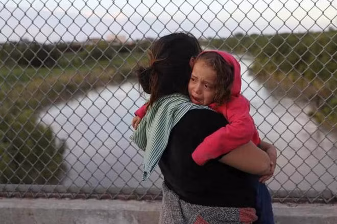 A Honduran mother and her 3-year-old daughter seeking asylum wait on the Mexican side of the Brownsville-Matamoros International Bridge after being denied entry by U.S. Customs and Border Protection officers near Brownsville, Texas, U.S., June 24, 2018. REUTERS/Loren Elliott