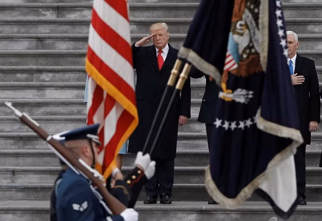 Newly inaugurated U.S. President Donald Trump salutes as he presides over a military parade following Trump's swearing-in ceremony in Washington, DC, U.S., January 20, 2017. REUTERS/Mike Segar/File Photo