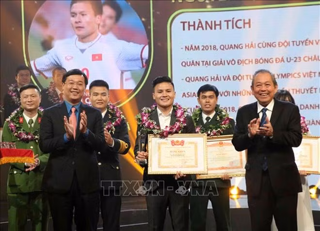 Deputy Prime Minister Truong Hoa Binh (R) presents the Outstanding Vietnamese Young Faces Award to fotballer Nguyen Quang Hai, the winner in the sports and physical training category (Photo: VNA) Deputy Prime Minister Truong Hoa Binh (R) presents the Outstanding Vietnamese Young Faces Award to fotballer Nguyen Quang Hai, the winner in the sports and physical training category (Photo: VNA)