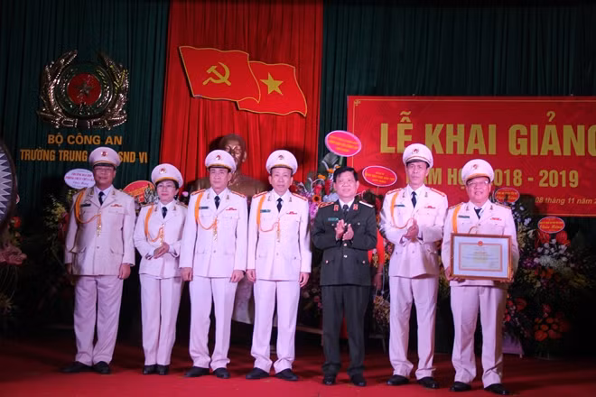 Deputy Minister Nguyen Van Son hands the Certificate of Merit by the MPS to the higher school.