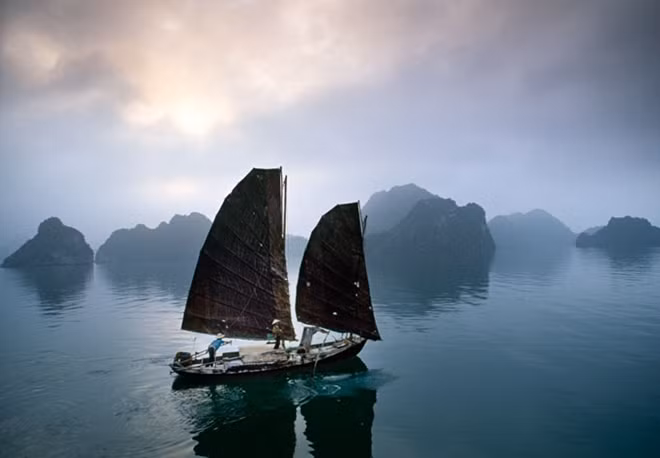 She loves travelling around Vietnam. "FISHING JUNK, HA LONG BAY, 1994 – Photographed in 1995, the traditional fishing junk no longer exists. Amongst Halong Bay's 2,000 islands — a UNESCO world heritage site — a fisherman plies the waters in an early morning fog. With a 3,800 kilometer coastline, fishing is a major industry in Vietnam, and the Vietnamese have always been daring and productive fishermen".