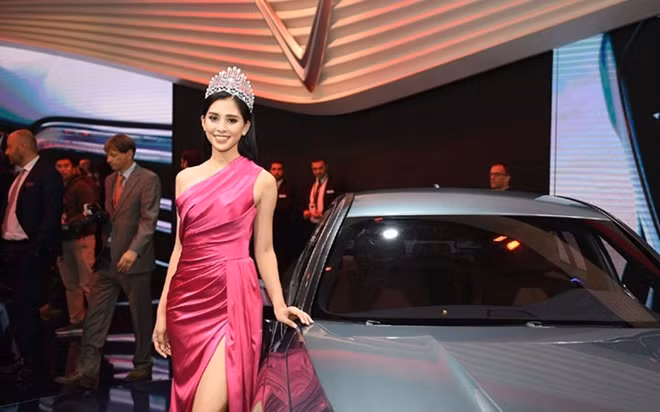 Vy poses for a picture next to a Vinfast car.