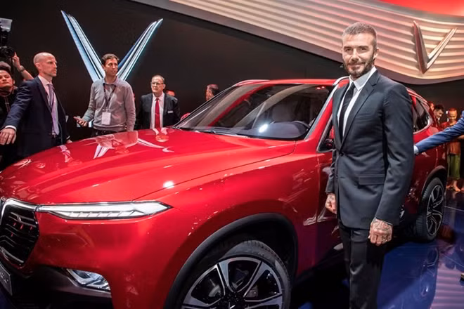 David Beckham takes a photo next to a Vinfast luxury car.