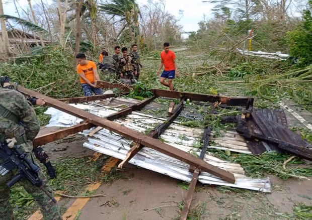 Rescue workers clear debris from the road after Typhoon Mangkhut swept through the Philippines. Photograph: Armed Forces of the Philippines Rescue workers clear debris from the road after Typhoon Mangkhut swept through the Philippines. Photograph: Armed Forces of the Philippines