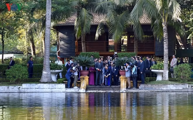 The two government leaders feed fish in the Uncle Ho pond.