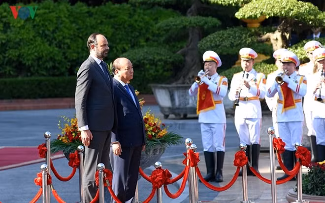 The two PMs step to the speakers’ podium before the national anthems of the two countries are played.